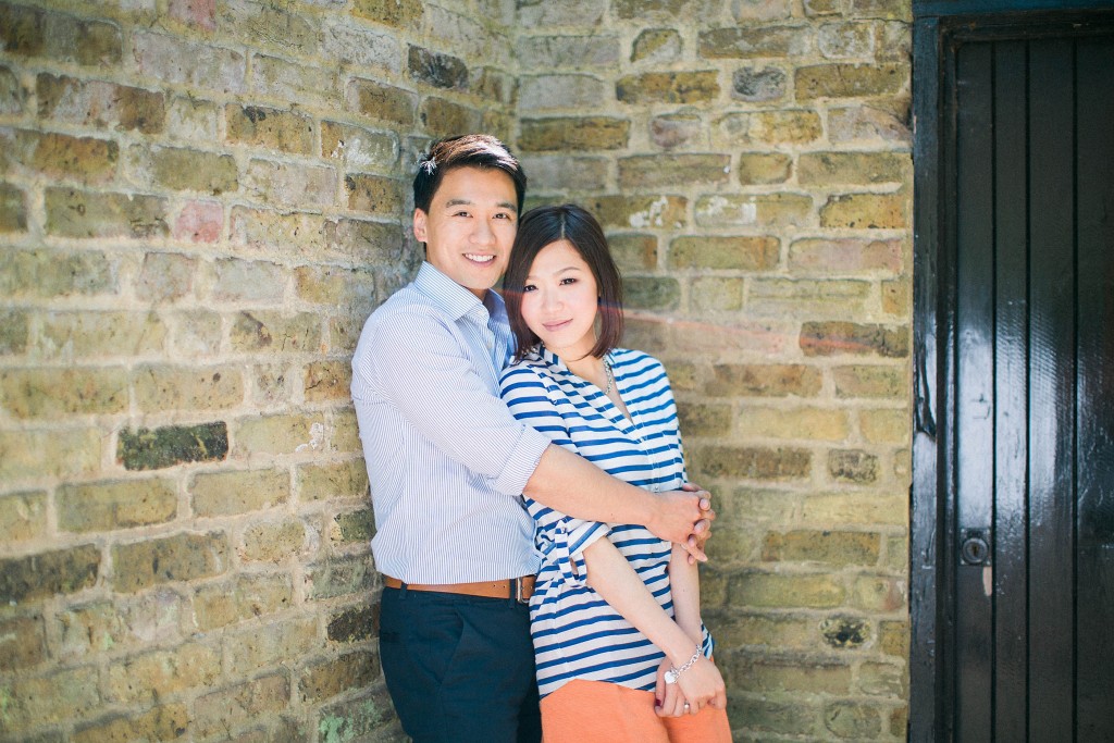 nicholas-lau-nicholau-weddings-beautiful-film-photography-love-london-engagement-couple-romance-amour-cute-sunny-sunlight-summer-chinese-asian-hug-from-behind-brick-wall-urban-couple