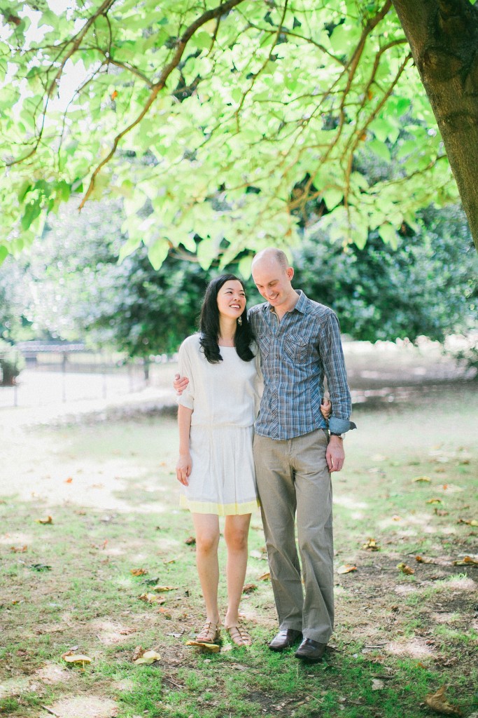 nicholas-lau-nicholau-weddings-london-film-photography-beautiful-pretty-engagement-love-interracial-asian-white-arm-around-her-guidance-sunny-summer-park-garden