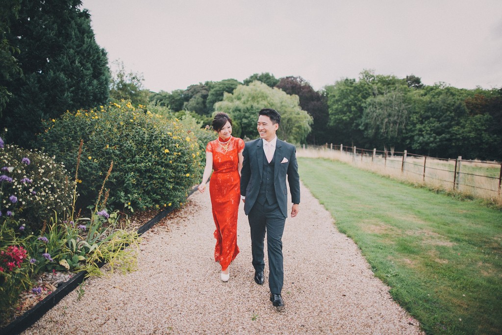 nicholas-lau-nicholau-london-film-fine-art-photography-beautiful-blog-first-wedding-love-cute-white-dress-chinese-asian-Gaynes-park-red-qipao-grey-suit-walking-hand-and-hand-bride-and-groom