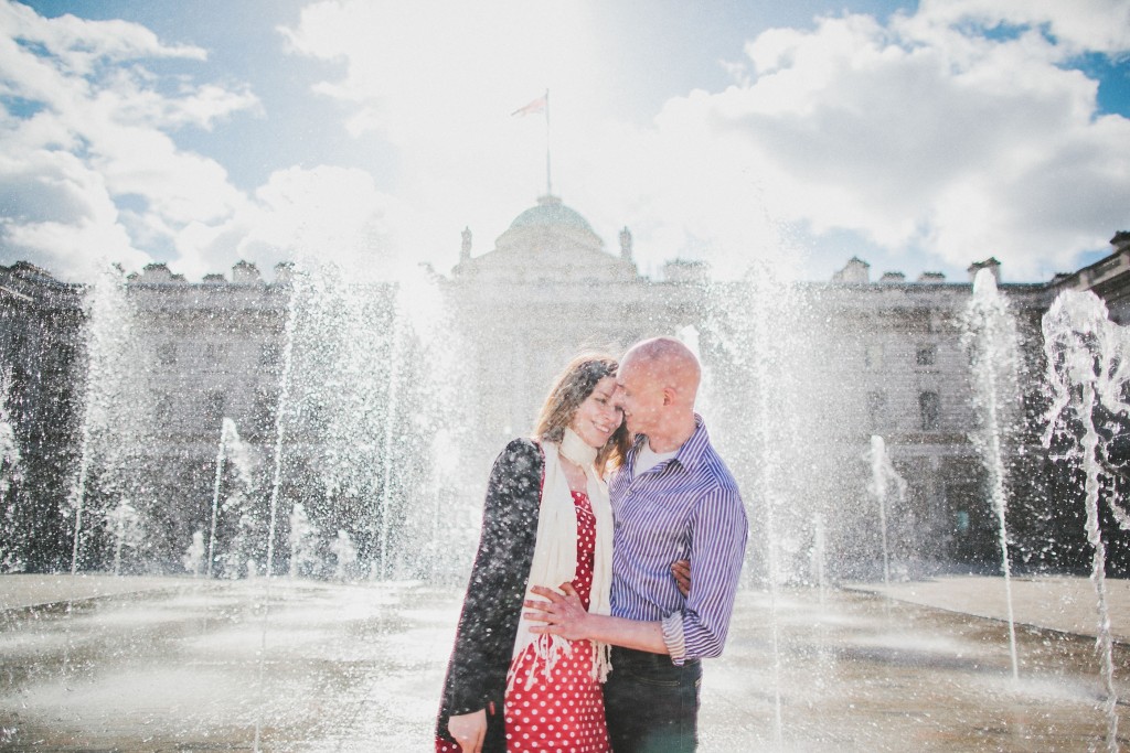 nicholas-lau-nicholau-lincolns-inns-fields-somerset-house-engagement-couple-photos-prewedding-love-london-holding-smiling-getting-wet-fountains-sun-flare-endearing