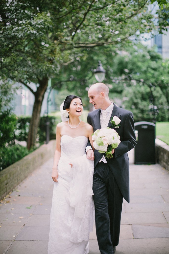 nicholau-nicholas-lau-interracial-wedding-groom-holds-bride-and-bouquet-charming-garden-stroll