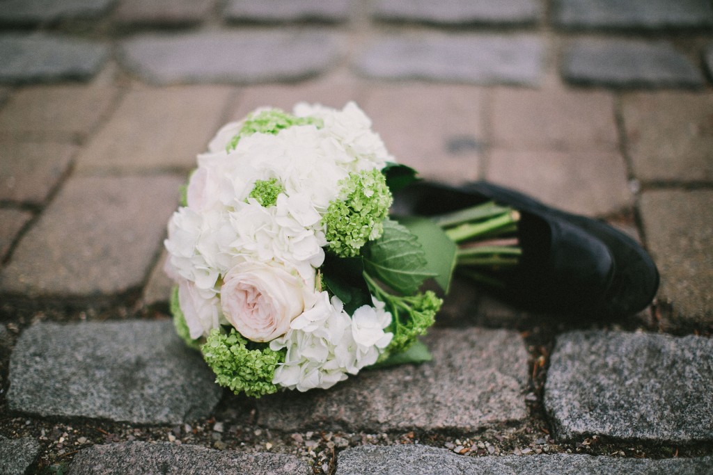 nicholau-nicholas-lau-interracial-wedding-shoe-and-a-bouquet-on-the-ground-white-roses-cobblestones