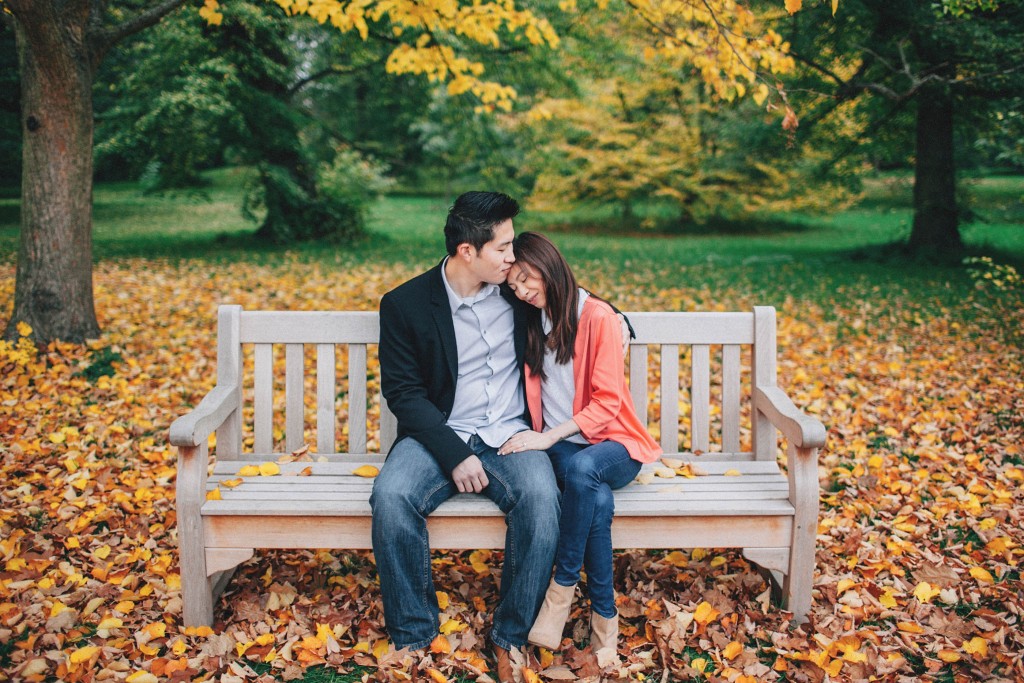 nicholau-nicholas-lau-couple-pre-wedding-film-fine-art-photography-red-blazer-leaves-fall-autumn-kew-gardens-uk-london-bench-rest-head-on-shoulder-trees