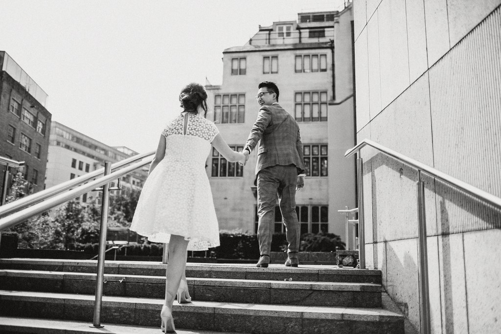 nicholas-lau-nicholau-photo-photography-fine-art-hybrid-engagement-chinese-asian-couple-london-uk-white-dress-grey-suit-ascending-stairs-together-black-white